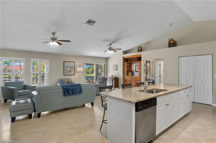 Kitchen featuring white cabinets, sink, stainless steel dishwasher, and ceiling fan