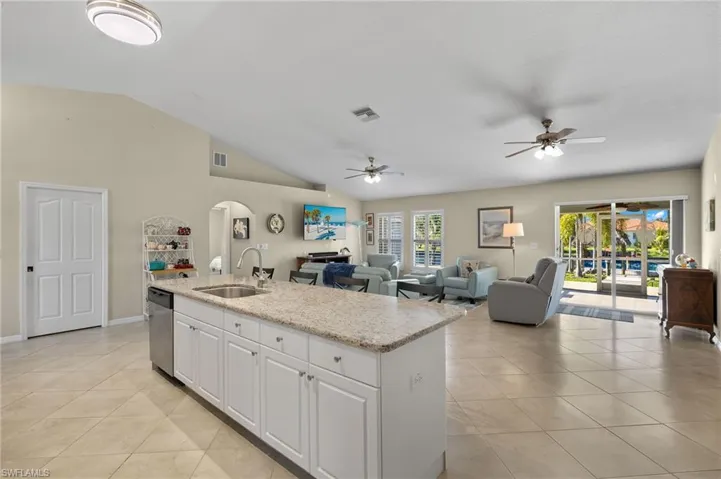Kitchen with white cabinets, sink, ceiling fan, and dishwasher