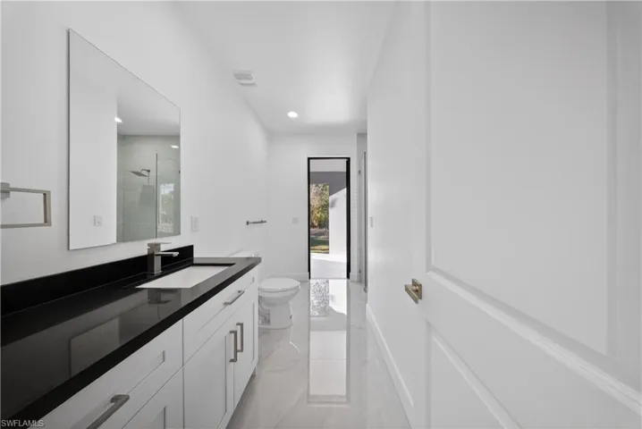 Bathroom featuring a stall shower, vanity, and recessed lighting