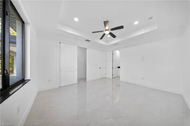 Unfurnished bedroom with a ceiling fan, recessed lighting, and light marble finish flooring