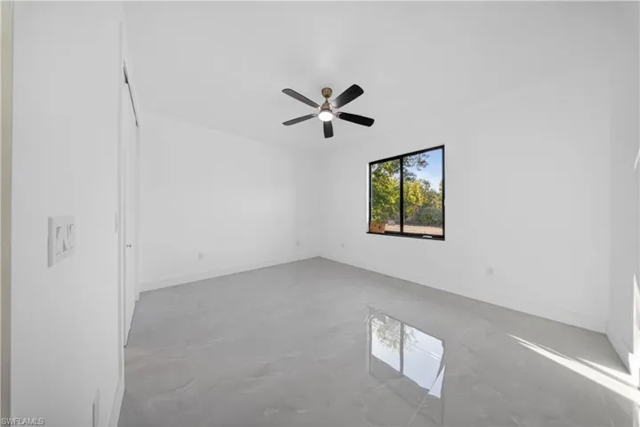 Unfurnished room with baseboards and ceiling fan