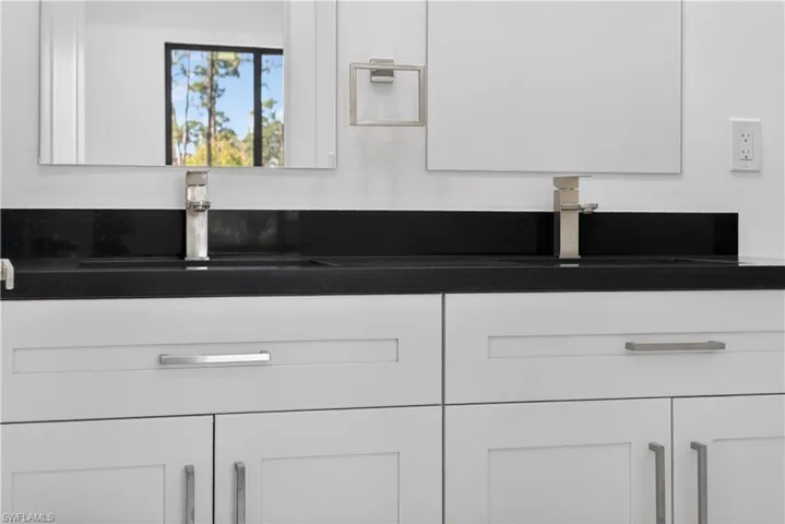 Detailed view of white cabinetry and dark countertops