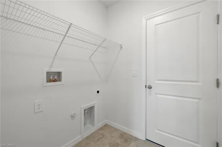 Laundry room with light tile floors, washer hookup, electric dryer hookup, and hookup for a gas dryer