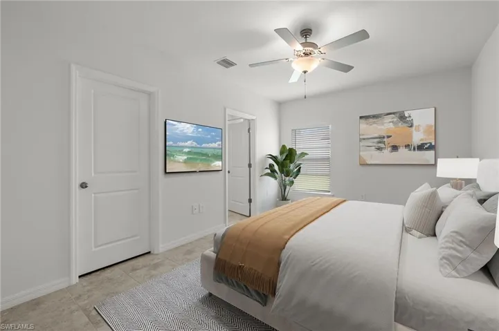 Tiled bedroom featuring multiple windows and ceiling fan
