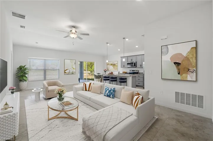 Living room featuring sink, ceiling fan, and light tile floors