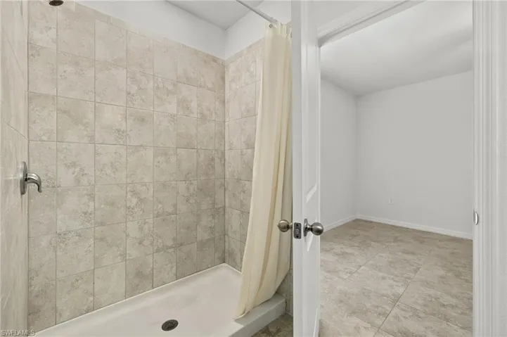 Bathroom with a shower with curtain and tile flooring