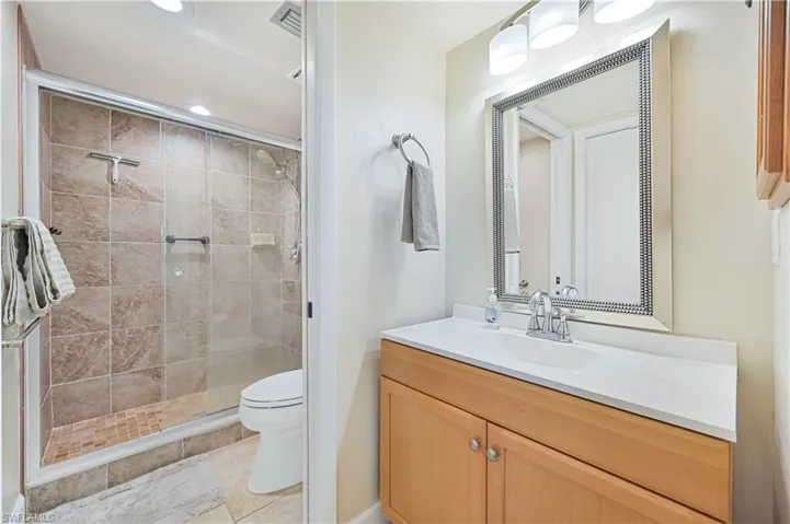 Full bathroom featuring vanity, a shower stall, light tile patterned flooring, and recessed lighting
