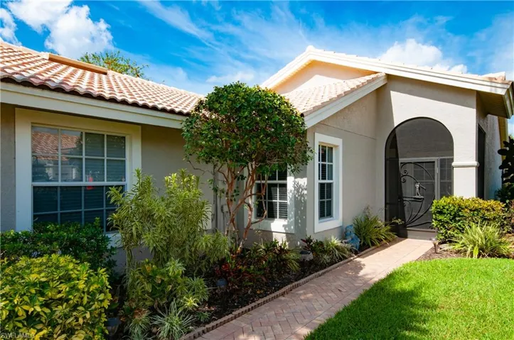 Entrance to property featuring a tile roof and stucco siding