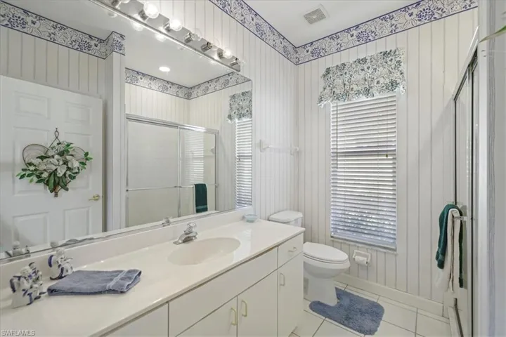 Full bath featuring visible vents, toilet, a stall shower, vanity, and tile patterned flooring