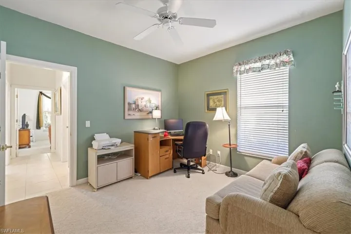 Office space with light carpet, baseboards, and a ceiling fan