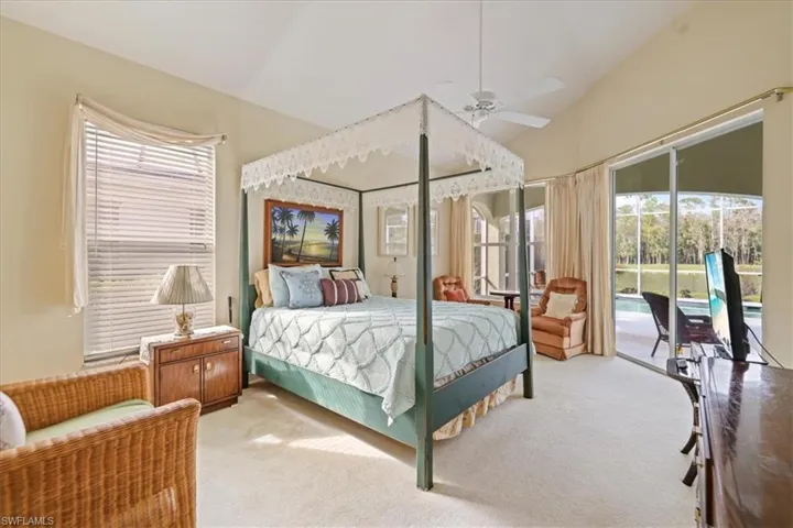 Bedroom featuring lofted ceiling, a sunroom, light carpet, ceiling fan, and access to outside