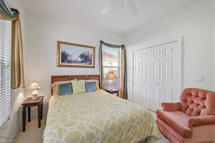 Bedroom with ceiling fan, a closet, and carpet flooring