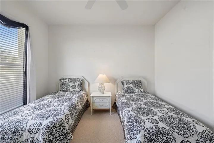 Carpeted bedroom with a ceiling fan