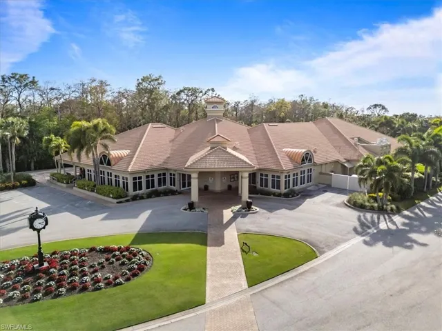 Shingle-style home with driveway, a tile roof, and a front lawn