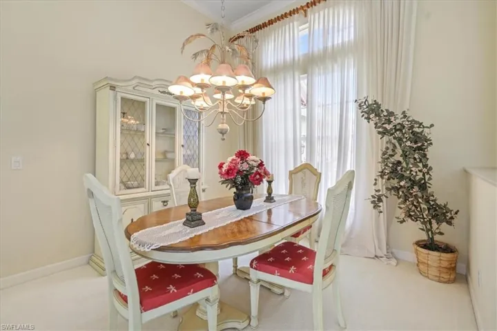 Dining room with crown molding, carpet flooring, a notable chandelier, and baseboards