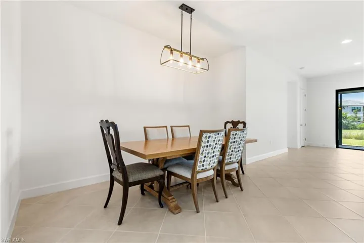 Tiled dining space featuring an inviting chandelier