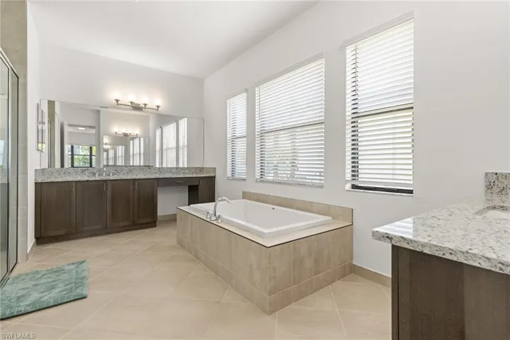 Bathroom with tile patterned floors, separate shower and tub, and vanity
