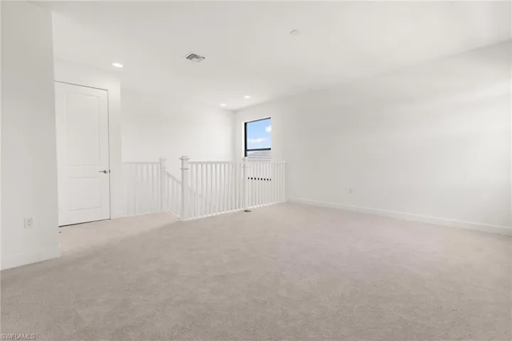 Unfurnished room featuring light carpet