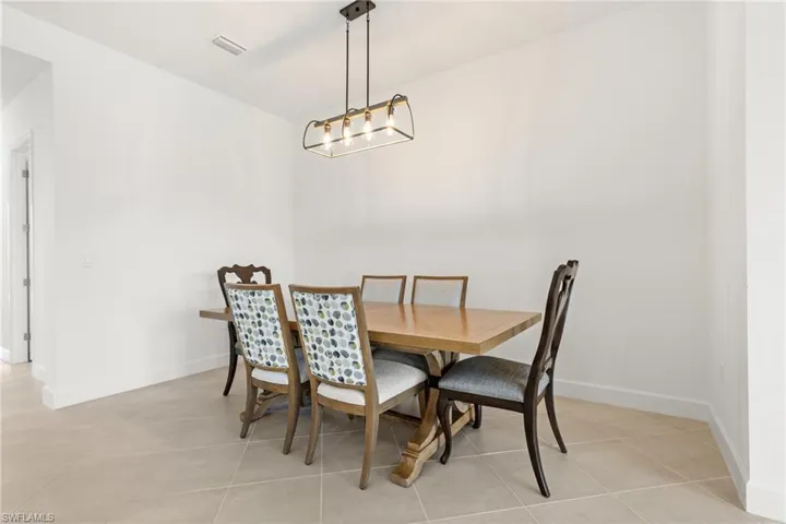 Tiled dining space featuring an inviting chandelier