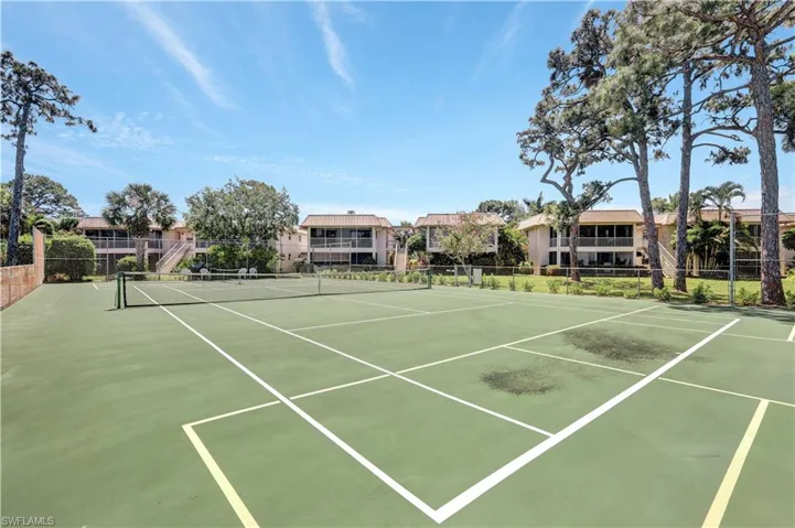 View of tennis and pickleball court featuring community basketball court and a residential view
