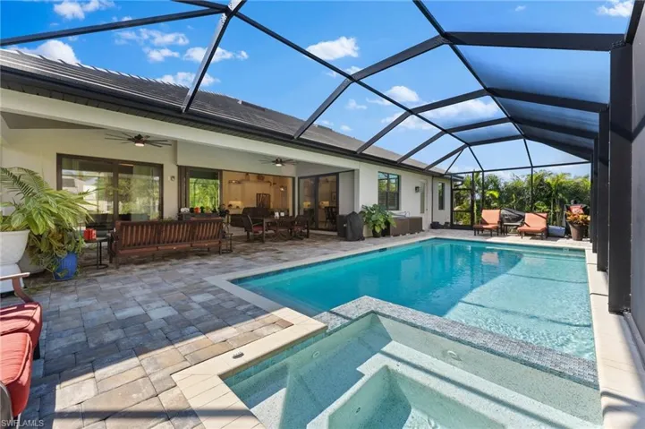 View of swimming pool with ceiling fan, outdoor lounge area, screen enclosure, a patio area, and an in ground spa