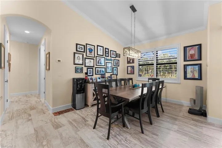 Dining space with lofted ceiling and crown molding