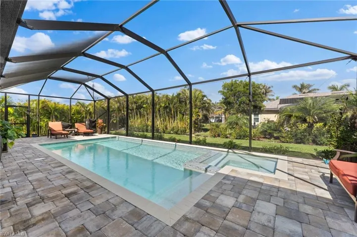 View of swimming pool with a patio, an in ground spa, and screen enclosure