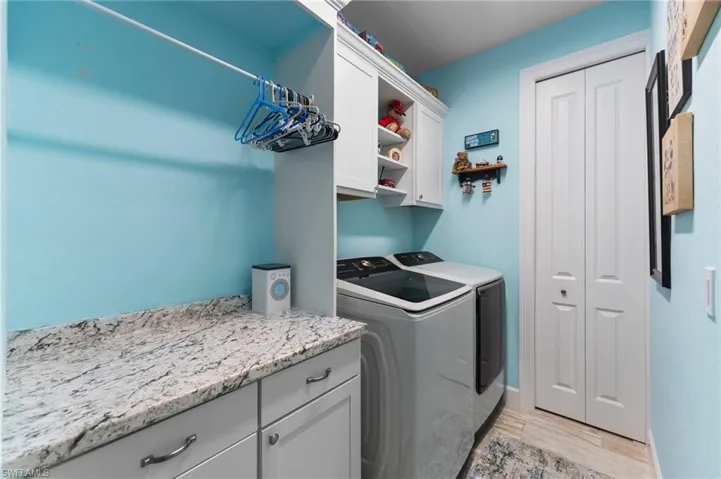 Laundry area featuring cabinets, independent washer and dryer, and upgraded porcelain flooring