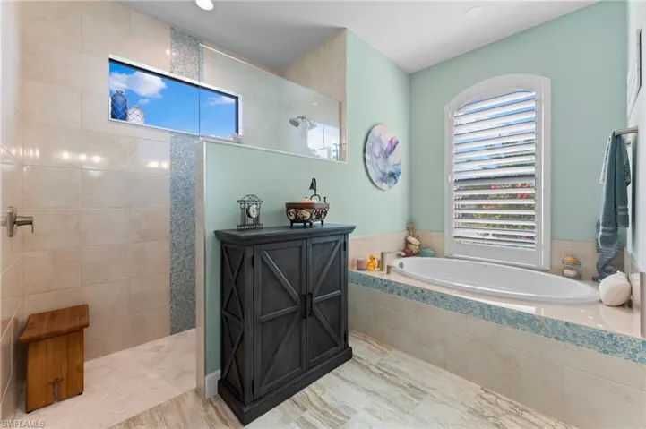 Bathroom is light & bright, featuring a large walk-in shower.