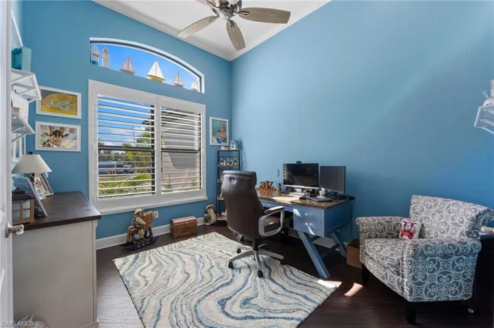 Office area featuring ornamental molding, dark wood-type flooring, and ceiling fan