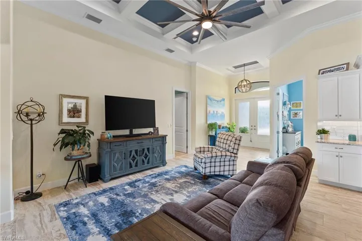 Open Concept Great Room home with towering 12ft ceiling, 1ft additional coffered ceiling, ornamental molding, french doors, and beamed ceiling