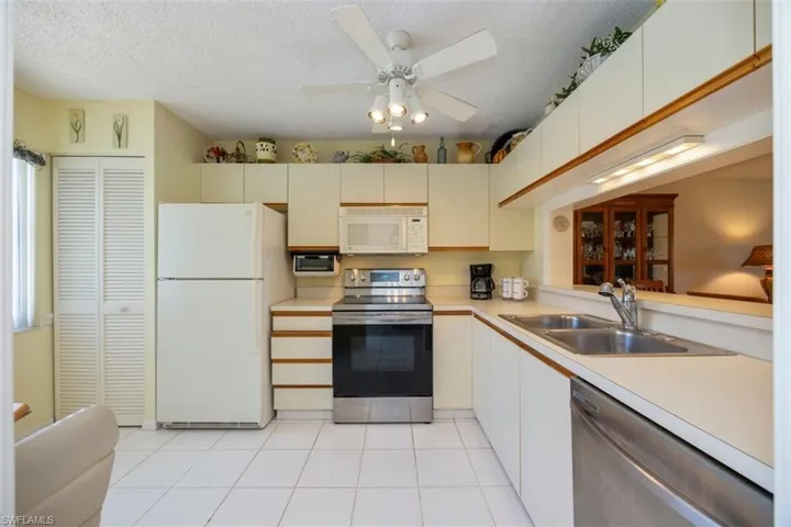 Kitchen with light countertops, light tile patterned floors, stainless steel appliances, a textured ceiling, and a sink