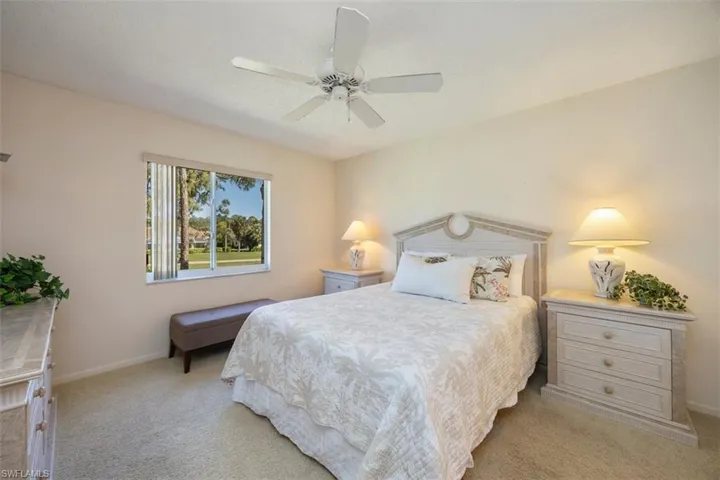 Bedroom featuring baseboards, a ceiling fan, and light colored carpet