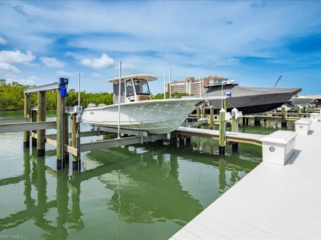 Dock area featuring boat lift and a water view