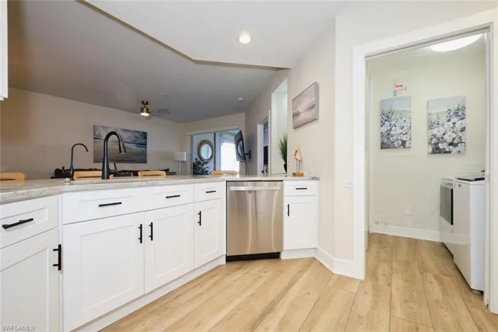 Kitchen with light hardwood / wood-style flooring, white cabinetry, ceiling fan, stainless steel dishwasher, and kitchen peninsula