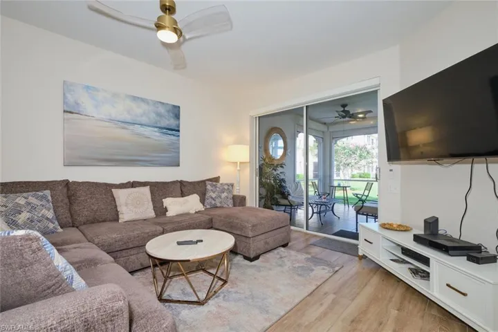 Living room with light hardwood / wood-style floors and ceiling fan