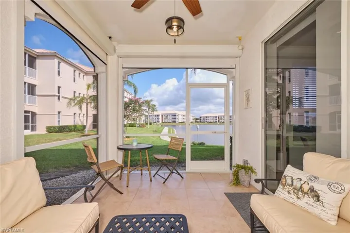 Sunroom / solarium with ceiling fan, a water view, and a wealth of natural light