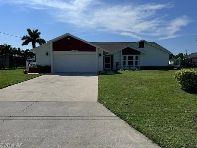 Single story home with a garage and a front yard