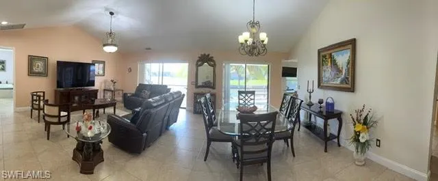 Tiled living room with an inviting chandelier and lofted ceiling