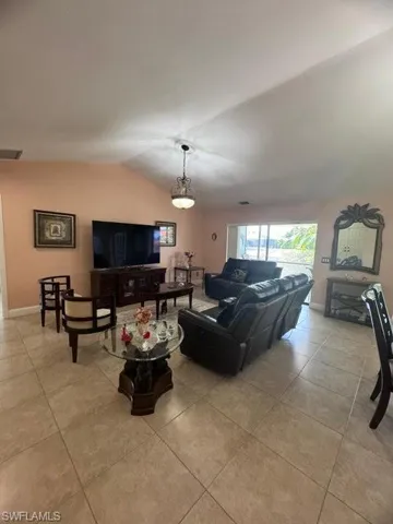 Tiled living room featuring vaulted ceiling