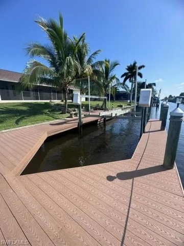 Dock area featuring a water view and a yard