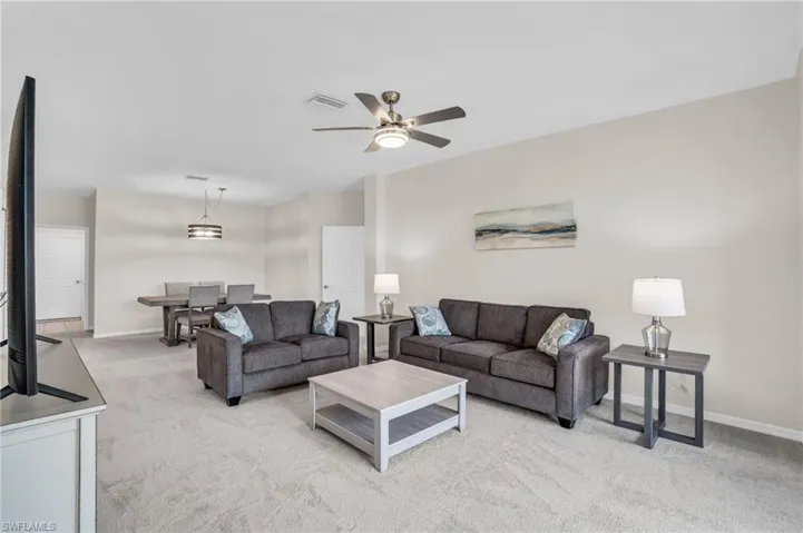 Carpeted living room with ceiling fan