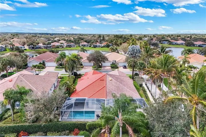 Aerial perspective of suburban area with a nearby body of water and a pool area