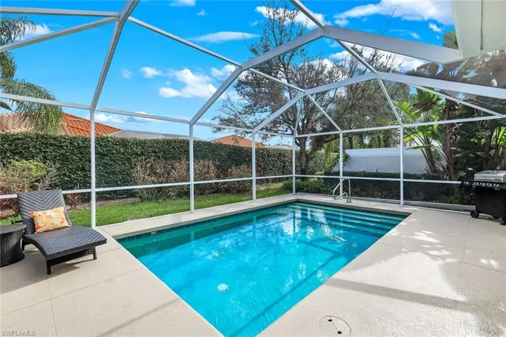 View of swimming pool featuring a sunroom, a fenced backyard, and a grill