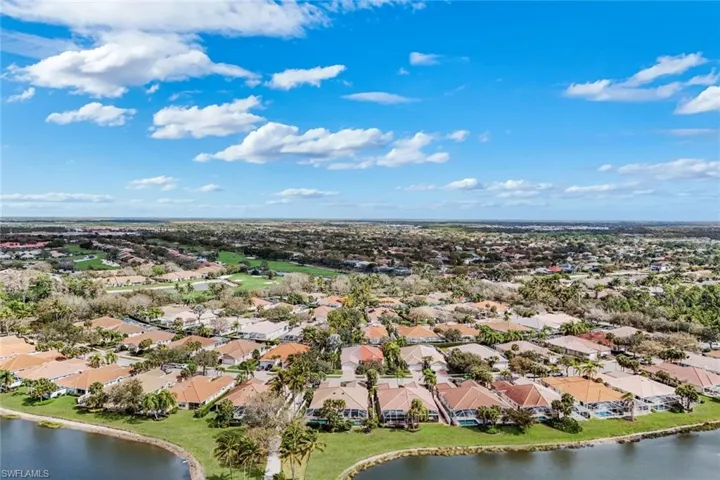 Aerial perspective of suburban area featuring a nearby body of water