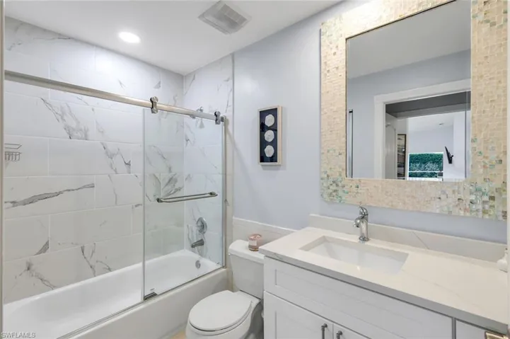 Full bath with vanity, bath / shower combo with glass door, and recessed lighting