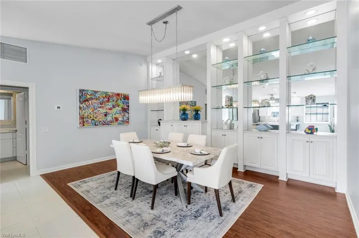Dining area with dark wood finished floors, a high ceiling, and recessed lighting