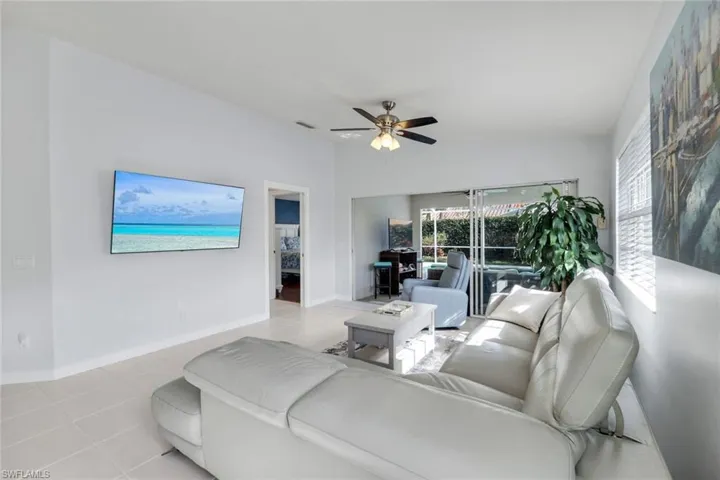 Living area with a ceiling fan and light tile patterned floors