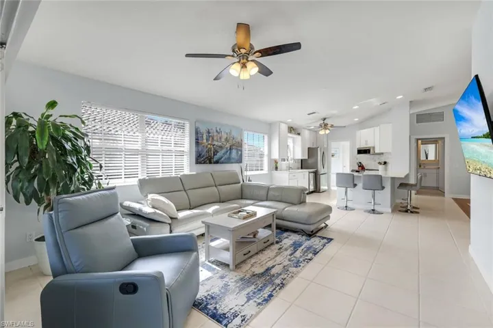 Living room featuring light tile patterned floors, vaulted ceiling, recessed lighting, and a ceiling fan