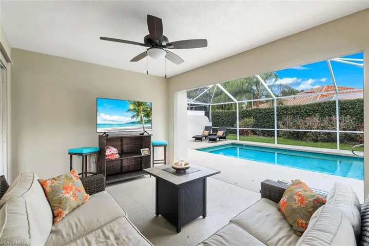 View of pool featuring an outdoor hangout area, a sunroom, patio surround, and glass enclosure